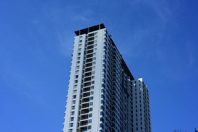 Low angle view of modern buildings against blue sky