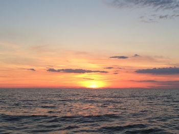 Scenic view of sea against dramatic sky during sunset