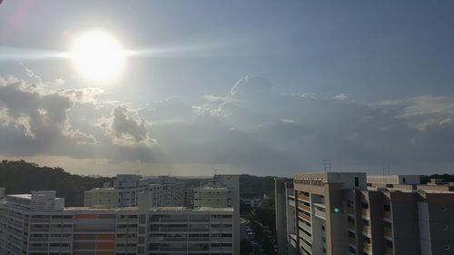 Buildings in city against cloudy sky