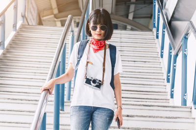 Young woman walking down staircase in city