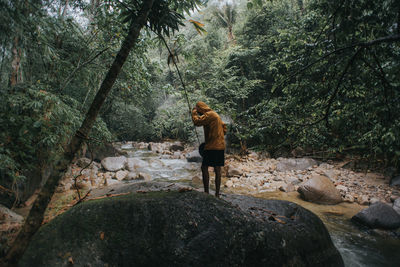 Woman standing on rock in forest