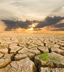 Rocks on land against sky during sunset