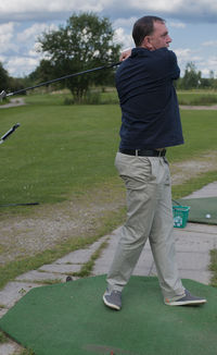 Rear view of man standing on golf course