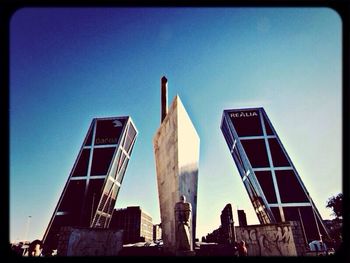 Low angle view of buildings against clear blue sky