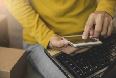 Midsection of man using mobile phone