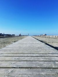 Scenic view of beach against clear blue sky