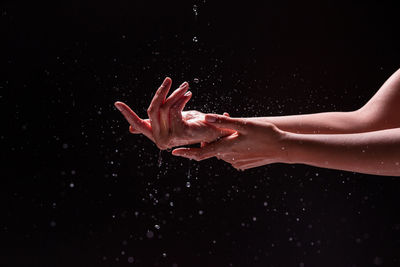 Close-up of wet hand against black background