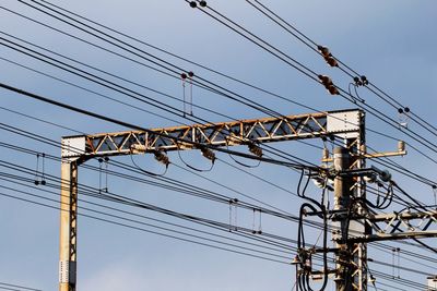 Low angle view of electricity pylon against clear sky