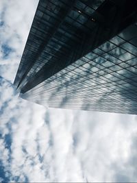 Low angle view of modern building against cloudy sky