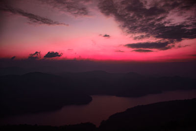 Scenic view of silhouette mountains against romantic sky at sunset