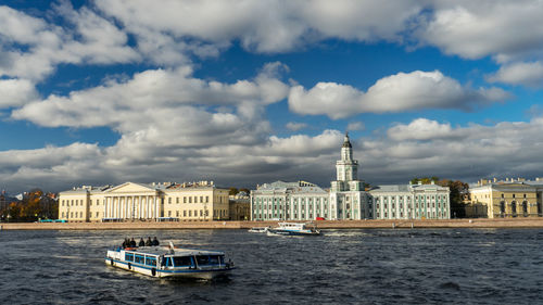 Boat in river against buildings in city