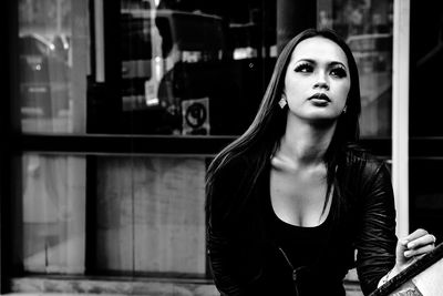 Young woman looking through window