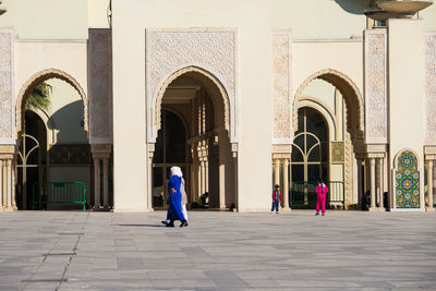 Rear view of people walking on building