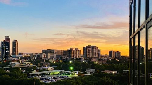 Buildings in city against sky during sunset