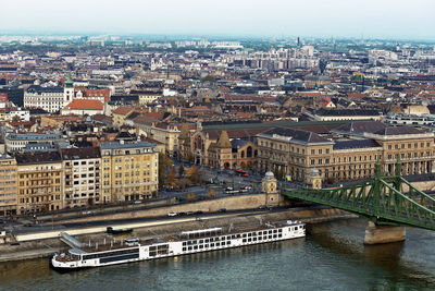 Liberty bridge on danube river and market at sunset, budapest, hungary