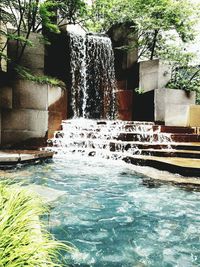 Water fountain in swimming pool against trees