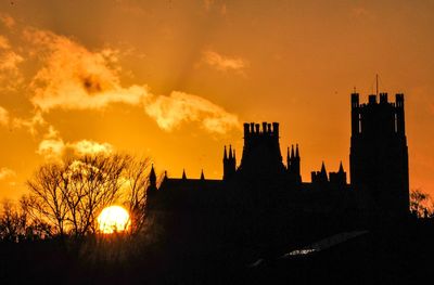 Silhouette buildings against sky during sunset