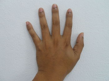 Cropped hand touching wall