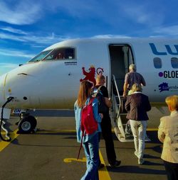 People standing on airplane against sky