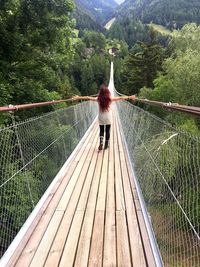 Rear view of woman on footbridge