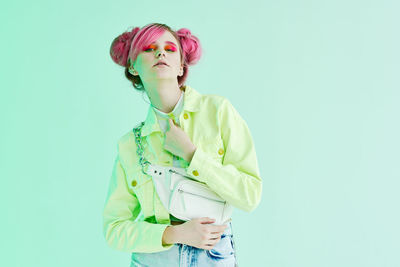 Young woman standing against blue background