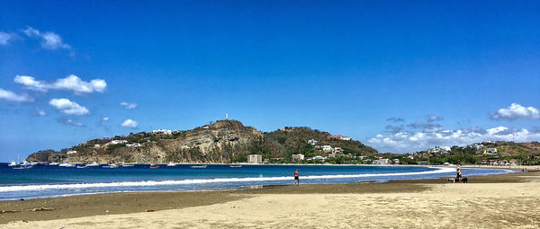 Scenic view of beach against blue sky