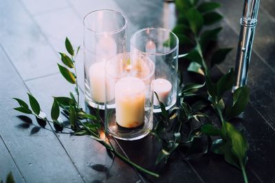 High angle view of lit candles in glass on floor