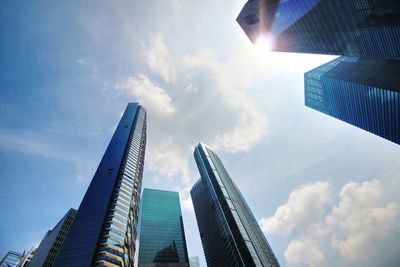 Low angle view of skyscrapers against cloudy sky