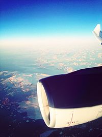 Low angle view of airplane wing over landscape