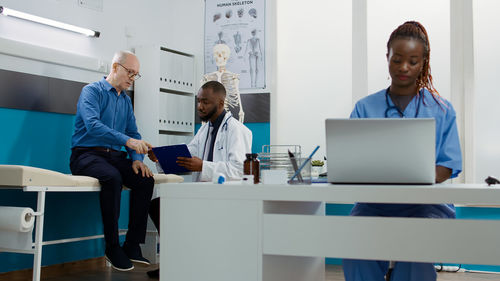 Portrait of doctor using laptop at office