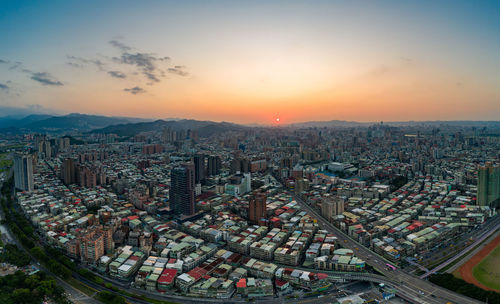 High angle view of modern buildings against sky during sunset