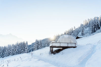 Winter igloo eco hotel in swiss mountauns covered by white snow at sunrise at morning. luxury pod 