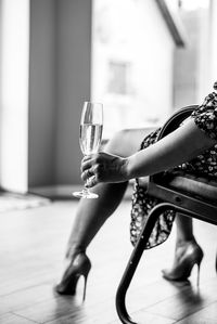 Side view of woman holding glass of wine