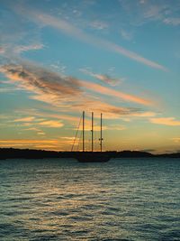 Silhouette sailboat on sea against sky during sunset