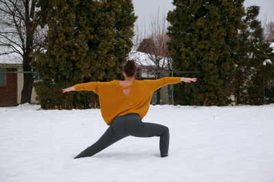 Full length of woman with umbrella in snow