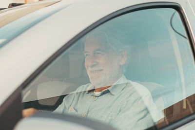 Smiling senior man sitting in car