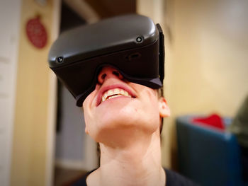 Portrait of smiling woman using mobile phone at home