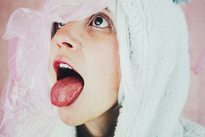 Close-up of woman in costume with pink plastic against wall