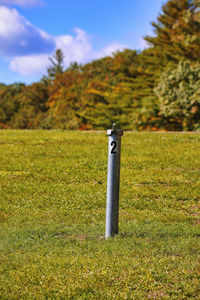 Metal structure on field against sky