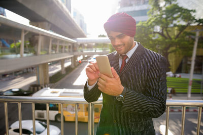 Young man using mobile phone in city