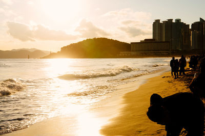 Silhouette man on beach against sky during sunset