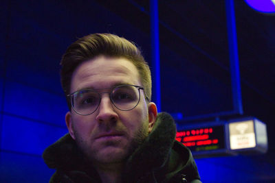 Portrait of young man wearing eyeglasses at night