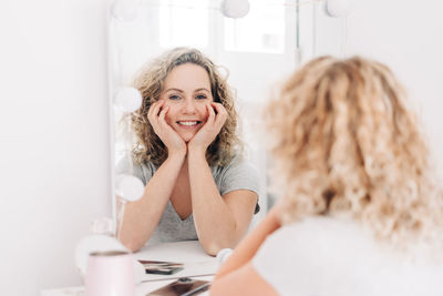 Portrait of a smiling young woman using phone