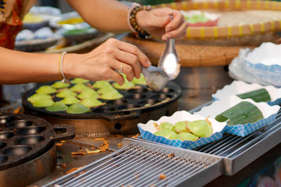 Cropped image of man preparing food on barbecue grill