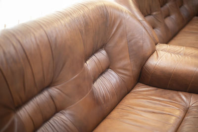 Leather sofa. furniture for relaxation. sofa is brown. old bed. seating for guests.