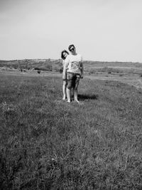 Portrait of woman standing on field against sky