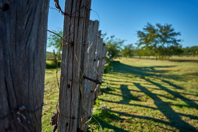 Wooden fence on field against sky