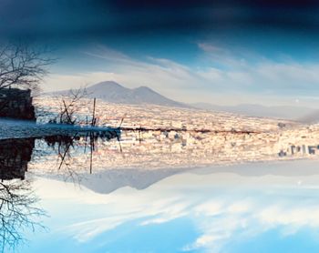 Scenic view of lake by mountains against sky
