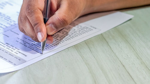 Close-up of man using mobile phone on table
