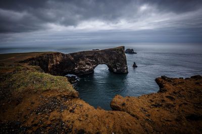 Scenic view of sea against cloudy sky at dusk